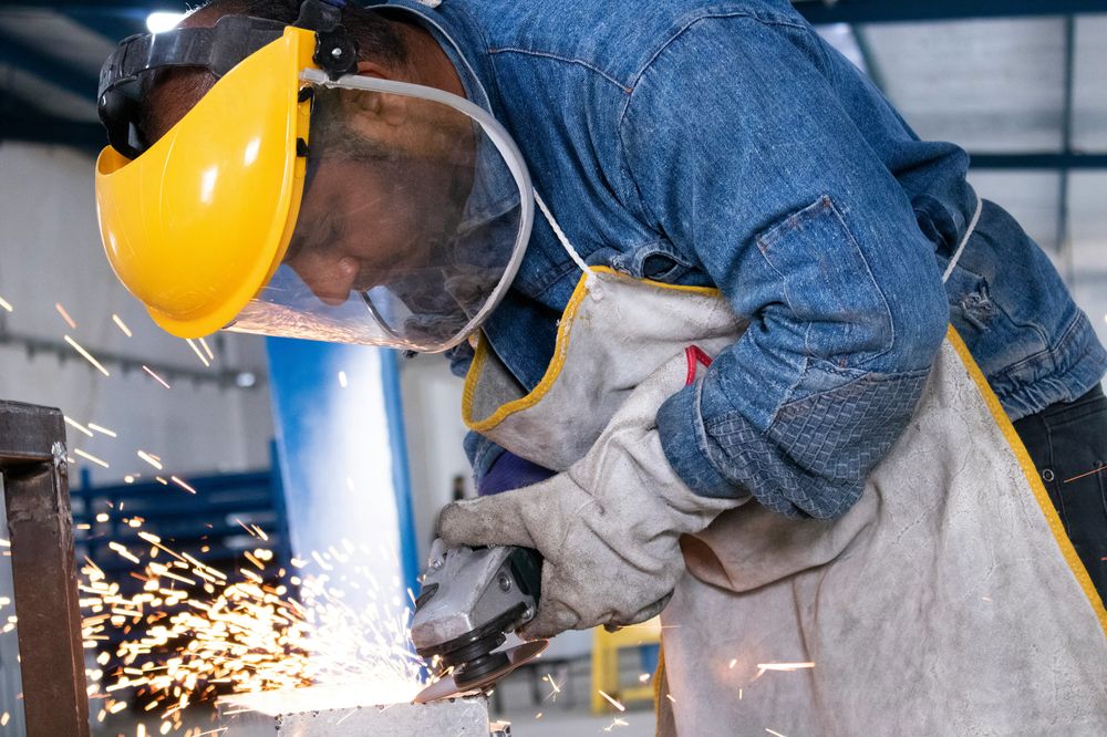 Fabricator grinding a steel component in the Fortalum workshop